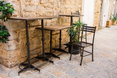 Ağaçların altındaki kafede boş hasır sandalyeler. Konukseverlik hizmeti, mevsimlik turizm ve kamusal alanlarda yaz tatili