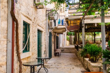 Taş duvarları, yeşil panjurları ve rahat bir kafesi olan dar bir Akdeniz sokağı. Şehir cazibesi, konukseverlik ve güney Avrupa yaşam tarzı