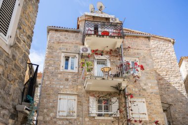 Balkonlu eski Akdeniz taş evi. Şehir cazibesi, tarihi mimari, dikey yaşam ve çiçek estetiği.
