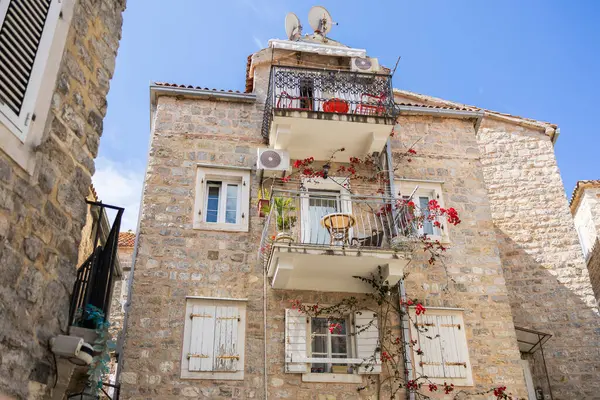 Balkonlu eski Akdeniz taş evi. Şehir cazibesi, tarihi mimari, dikey yaşam ve çiçek estetiği.