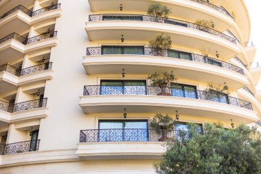 Demirden balkonları ve saksısı olan şık bir otel cephesi..