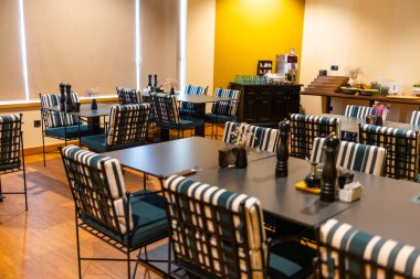 Çizgili sandalyeli ve açık büfe köşeli rahat kahvaltı odası. Modern yemek, konukseverlik tasarımı ve rahat bir sabah atmosferi.