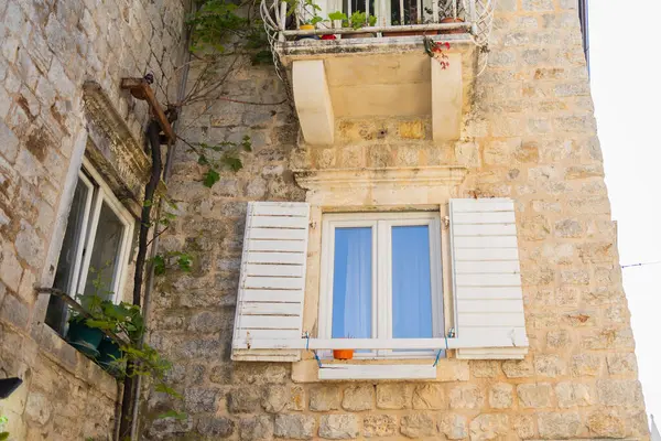 Kıyı güneşinde kepenkleri kapalı taş cephe. Yaz seyahati, mimari cazibe ve tarihi Avrupa sokaklarının samimiyeti.