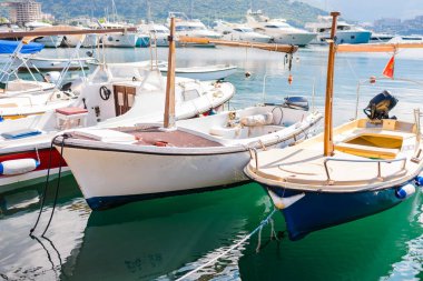 Arka planda modern kıyı silueti olan küçük tekneler marinada dizildi. Şehir turizmi, kıyı yaşamı ve Avrupa kıyı kasabalarında her gün tekne gezisi.