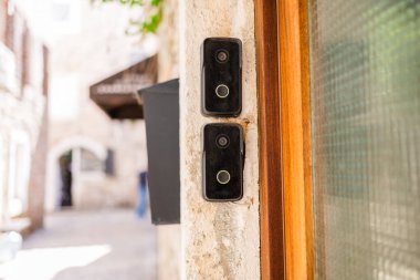 Eski taş girişteki akıllı kapı zilleri. Kentsel güvenlik, akıllı teknoloji ve geleneksel mimari ortamlarda modern yaşam.