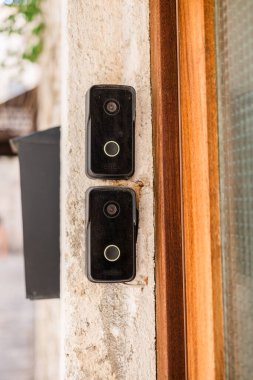 Eski taş girişteki akıllı kapı zilleri. Kentsel güvenlik, akıllı teknoloji ve geleneksel mimari ortamlarda modern yaşam