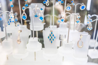 Mavi taşlı el yapımı gümüş kolyeler. Mücevher, zarafet ve zanaatkarlık bir butik vitrininde vurgulandı.