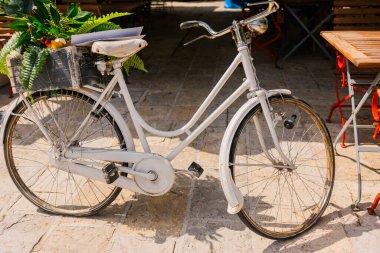 Akdeniz sokaklarında dinlenen klasik bir bisiklet. Sıradan ulaşım, zamansız sokak cazibesi ve kırsal şehir sakinliği.