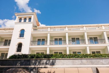 Balkonları ve dekoratif kulesi olan zarif bir sahil binası. Akdeniz mimarisi, otel cephesi ve güneşli seyahat yeri