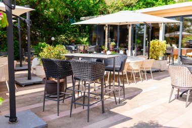 Modern hasır mobilyalı açık kafe terası. Konukseverlik, yaz tatili ve Akdeniz 'de bahçe yemeği.