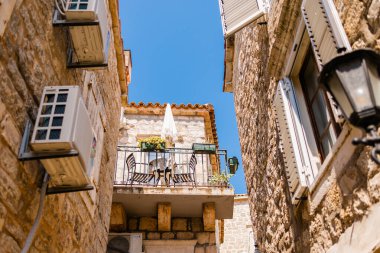 Sandalye ve şemsiyeli güneşli balkon. Akdeniz cazibesi, açık hava eğlencesi ve mimari sıcaklık.