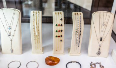 Renkli kolyeler ve değerli bilezikler sergileniyor. Mücevher aranjmanı, perakende zarafet ve lüks moda ayrıntıları.