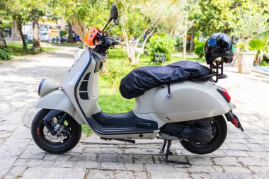 Çağdaş gri mobilet kaldırım taşı yolunda park edilmiş. Şehir içi taşıma, minimalist yaşam tarzı ve çevre dostu ulaşım kavramı