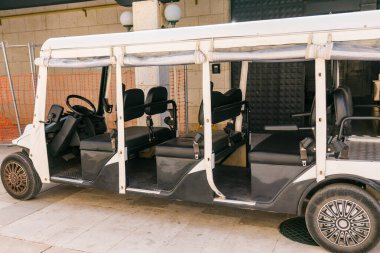 Tatil köyü misafirleri için elektrikli servis arabası. Sahilde dinlenme, tatil ortamı ve deniz kenarında yaz tatili.