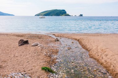 Karadağ 'da ada manzarası ve sakin bir kıyı. Sahilde dinlenme, tatil ortamı ve deniz kenarında yaz tatili.