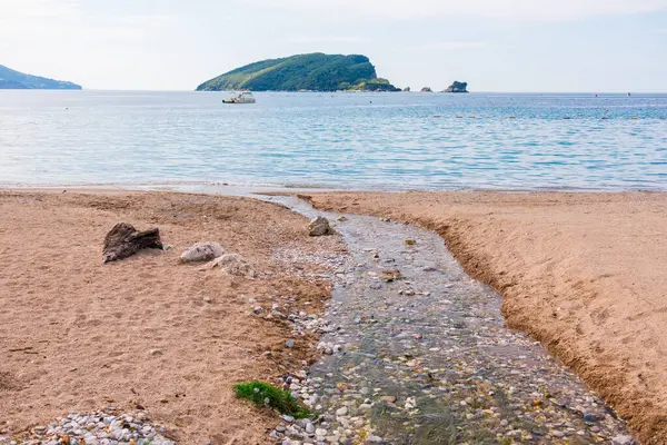 Karadağ 'da ada manzarası ve sakin bir kıyı. Sahilde dinlenme, tatil ortamı ve deniz kenarında yaz tatili.