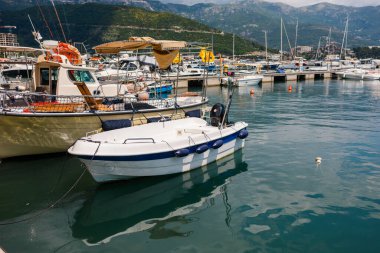 Arka planda modern kıyı silueti olan küçük tekneler marinada dizildi. Şehir turizmi, kıyı yaşamı ve Avrupa kıyı kasabalarında her gün tekne gezisi.