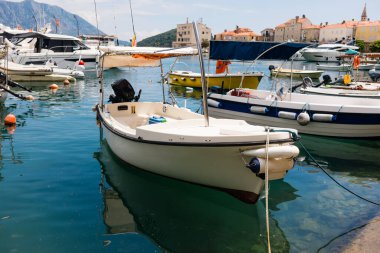 Küçük motorlu botlar sakin marina suyuna yanaştı. Deniz kenarı yaşam tarzı, sahil ulaşımı ve deniz yaz atmosferi.