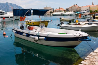 Küçük motorlu botlar sakin marina suyuna yanaştı. Deniz kenarı yaşam tarzı, sahil ulaşımı ve deniz yaz atmosferi.