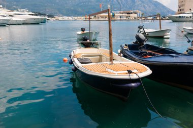 Küçük motorlu botlar sakin marina suyuna yanaştı. Deniz kenarı yaşam tarzı, sahil ulaşımı ve deniz yaz atmosferi.