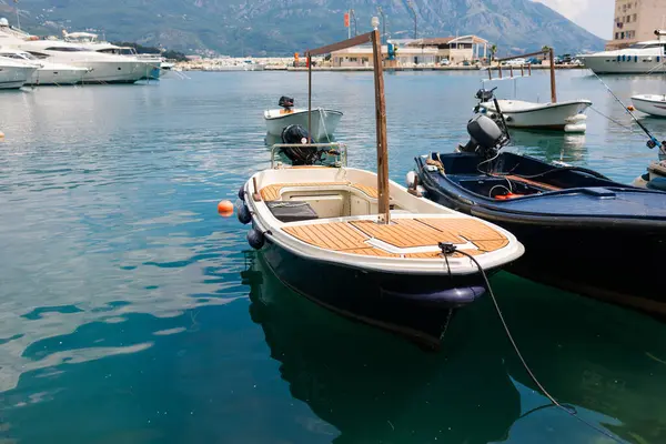 Küçük motorlu botlar sakin marina suyuna yanaştı. Deniz kenarı yaşam tarzı, sahil ulaşımı ve deniz yaz atmosferi.