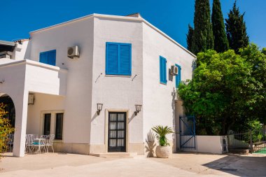 Mavi panjurlu beyaz evler. Akdeniz tasarımı, yaz iklimi adaptasyonu ve doğal elementlere sahip kıyı kentsel yaşam tarzı