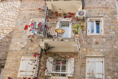 Balkonlu eski Akdeniz taş evi. Şehir cazibesi, tarihi mimari, dikey yaşam ve çiçek estetiği.