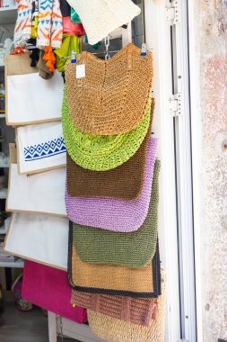 Sokak pazarında renkli dokuma çantalar sergileniyor. Yaz modası, çevre dostu aksesuarlar ve bohem tatil alışverişi.