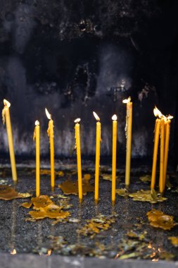 Kilise mabedinin içinde kumdaki mumları yaktı. Ruhani ritüeller, kişisel dualar ve kutsal gelenekleri anmanın sessiz gücü.