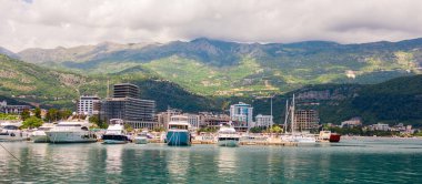 Lüks yatları ve dağ arkaplanı olan sahil kenti marinası. Karadağ 'da yaz tatili, tatil beldesi ve deniz manzarası