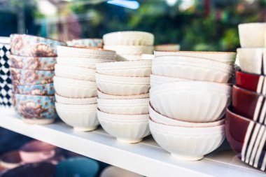 Rafta yığılmış beyaz seramik kaseler. Perakende gösteriminde mutfak eşyaları, seramik sofra takımı ve minimalist tasarım