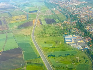 Otoyol manzarası ve şehrin yakınındaki yeşil alanlar. Şehir gelişimi, tarım manzarası ve yukarıdan yakalanan ulaşım ağı