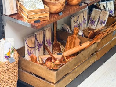 Ahşap mutfak aletleri ve tepsiler yerel bir dükkanda sergileniyor. El yapımı hatıralar, eko yaşam tarzı ve kırsal doğal tasarım.