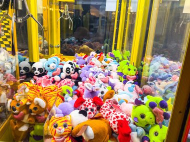 Renkli peluş hayvanlar ve oyuncaklarla dolu bir pençe makinesi. Oyun salonunda eğlence, eğlence, çocukluk ve eğlence.