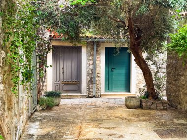 Sessiz taş bahçesinde iki farklı kapı var. Mimarlık, kentsel sakinlik ve Akdeniz yerleşim bölgesinde kültürel gelenek