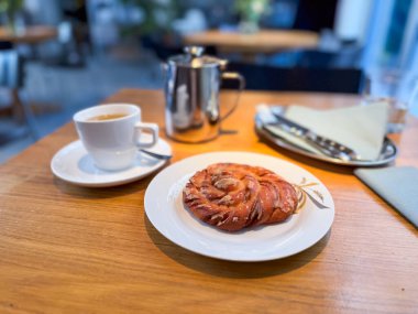 Tahta masada tatlı pastalı bir fincan kahve. Kahvaltı, hoşgörü, gastronomi ve kafe kültürü.