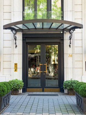 Cam ve metal tepe örtülü zarif bir giriş kapısı. Mimarlık, gayrimenkul ve şehir yaşam tarzı kavramı