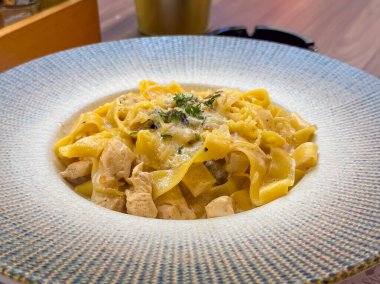 Kremalı soslu ve tavuklu lezzetli makarna. Restoran mutfağı, gurme yemekleri ve otantik İtalyan yemek fotoğrafçılığı.