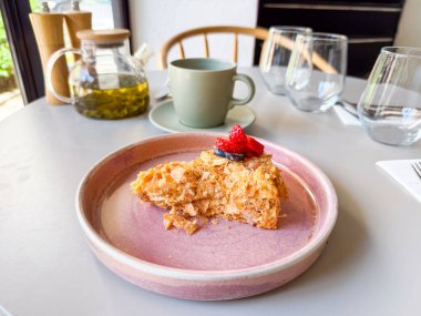 Kafede çay ile servis edilen böğürtlenli bir dilim pasta. Tatlı hoşgörü, yaşam tarzı yemek ve mutfak kültürünü simgeleyen tatlı ve içecek.