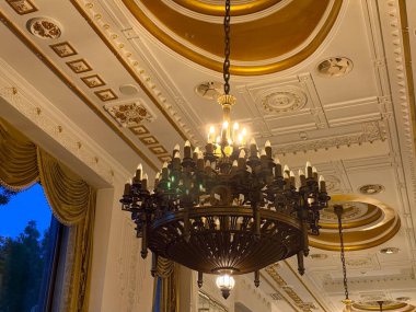 Lüks otelin avizesi ve altın tavanı süslenmiş. Klasik mimari, karmaşık detaylar ve zarif iç mekan.