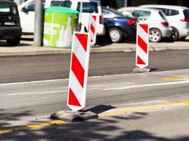 İnşaat çevresindeki trafiği yönlendirmek için bir şehir caddesine yansıtıcı kırmızı-beyaz çizgili yol çalışmaları yerleştirildi.