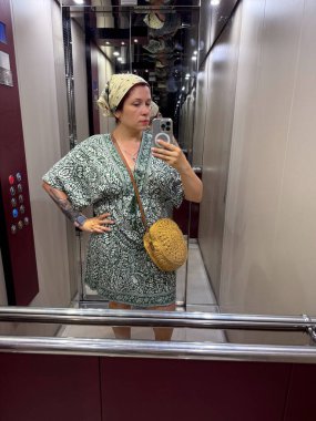 Asansörde aynalı selfie çeken bir kadın. Moda, yaşam tarzı ve şehir kimlik ifadesi
