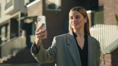 Genç iş kadını müşterilerini ararken ve kulaklık takarken videoya çekiliyor. Öğrenci akıllı telefon kullanıyor, internetten çalışıyor. İnsanlar, teknoloji ve iletişim konsepti