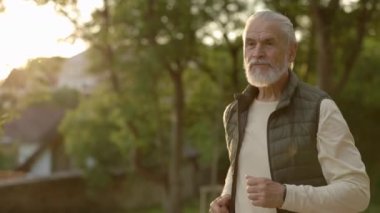 Olgun adam sokakta koşuyor. Yaşlı bir erkek dışarı koşuyor. Koşucu, liman ve sağlıklı yaşam tarzı konsepti. Genççe yaşlanıyor. İnsanlar ve spor konsepti