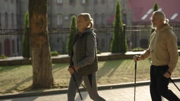 Glückliches Seniorenpaar Mit Trekkingstöcken Auf Der Straße Gemeinsam Nordic Walking — Stockvideo