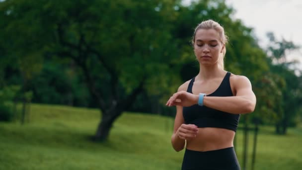 Blanke Vrouwelijke Atleet Staat Parken Het Instellen Van Fitness App — Stockvideo