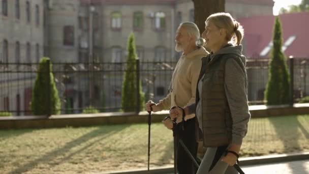 Yürüyüş Sopalarıyla Sokakta Yürüyen Mutlu Olgun Bir Çift Birlikte Nordic — Stok video