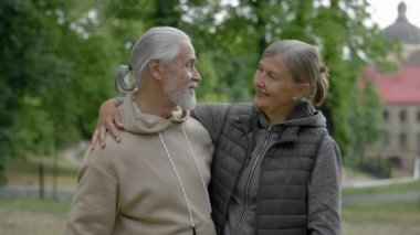 Parkta dikilmiş kucaklaşan sevimli olgun çiftin portresi. Yaşlı bir aile birbirine aşık. Millet, aşk ilişkisi kavramı