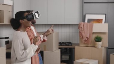 African american couple put on vr technology and estimates the apartment already furnished. African american couple use vr reality to see their new home fully furnished