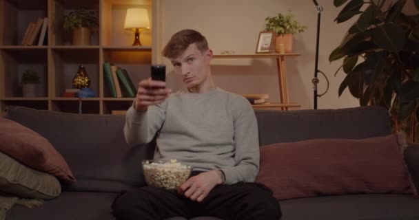 Handsome Millennial Man Taking Remote Controller Switching Caucasian Cheerful Male — Stock video